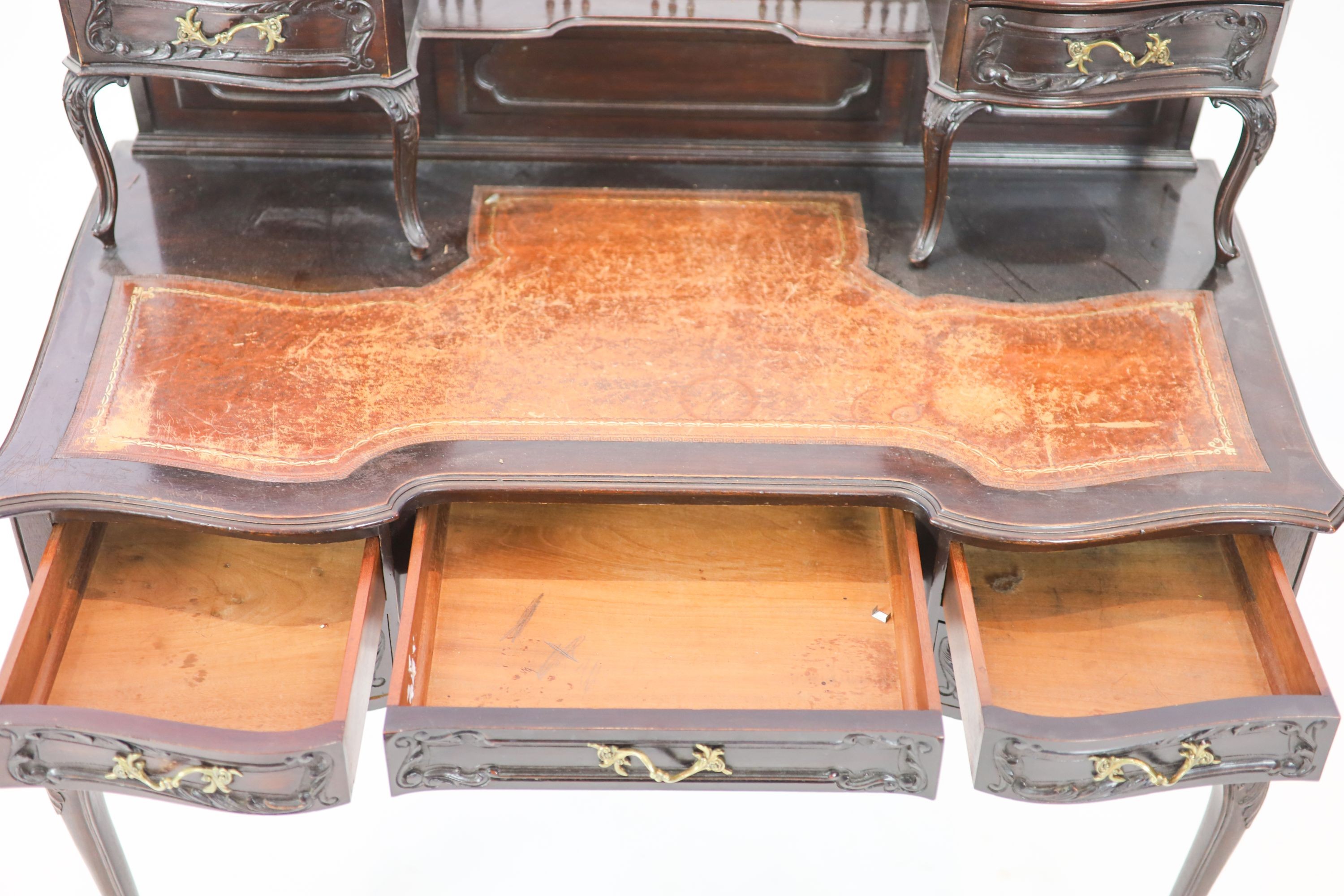 A late Victorian carved mahogany serpentine-shaped writing desk, length 106cm, depth 54cm, height 105cm